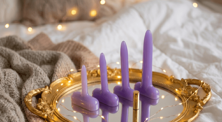 Sh! Purple silicone vaginal dilators on a gold tray with soft lighting and cozy background
