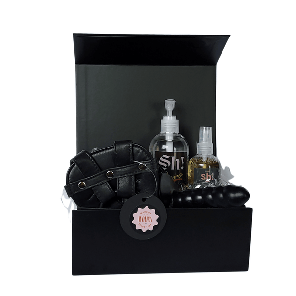 Beginner's Anal Strap - On Dildo Kit in a black gift box comprising small black ribbed silicone dildo, black leather harness, bottle of lube & toy cleaner.