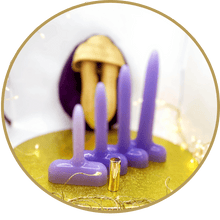 Vaginal dilators on a gold plate with out of focus vulva puppet in background