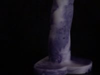 A video of the Cupid 2 dildo in white and purple marble silicone, against a black background. 