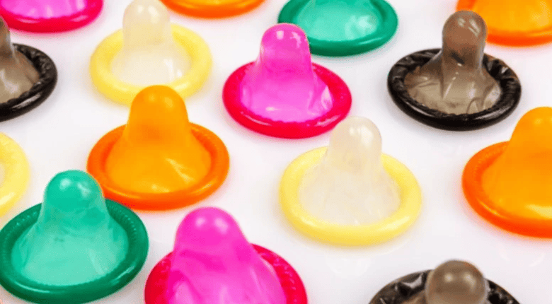 Colorful condoms on a rwhite surface