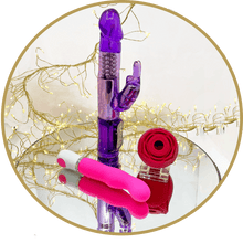 3 differnt types of vibrators - purple rabbit vibe, pink mini g-spot vibe & rose suction toy displayed on a mirror, surrounded by fairy lights